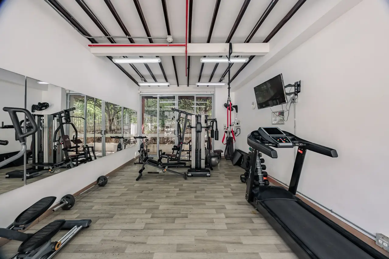Residents' gym with cardio and weight machines in the building at Balcón Verde