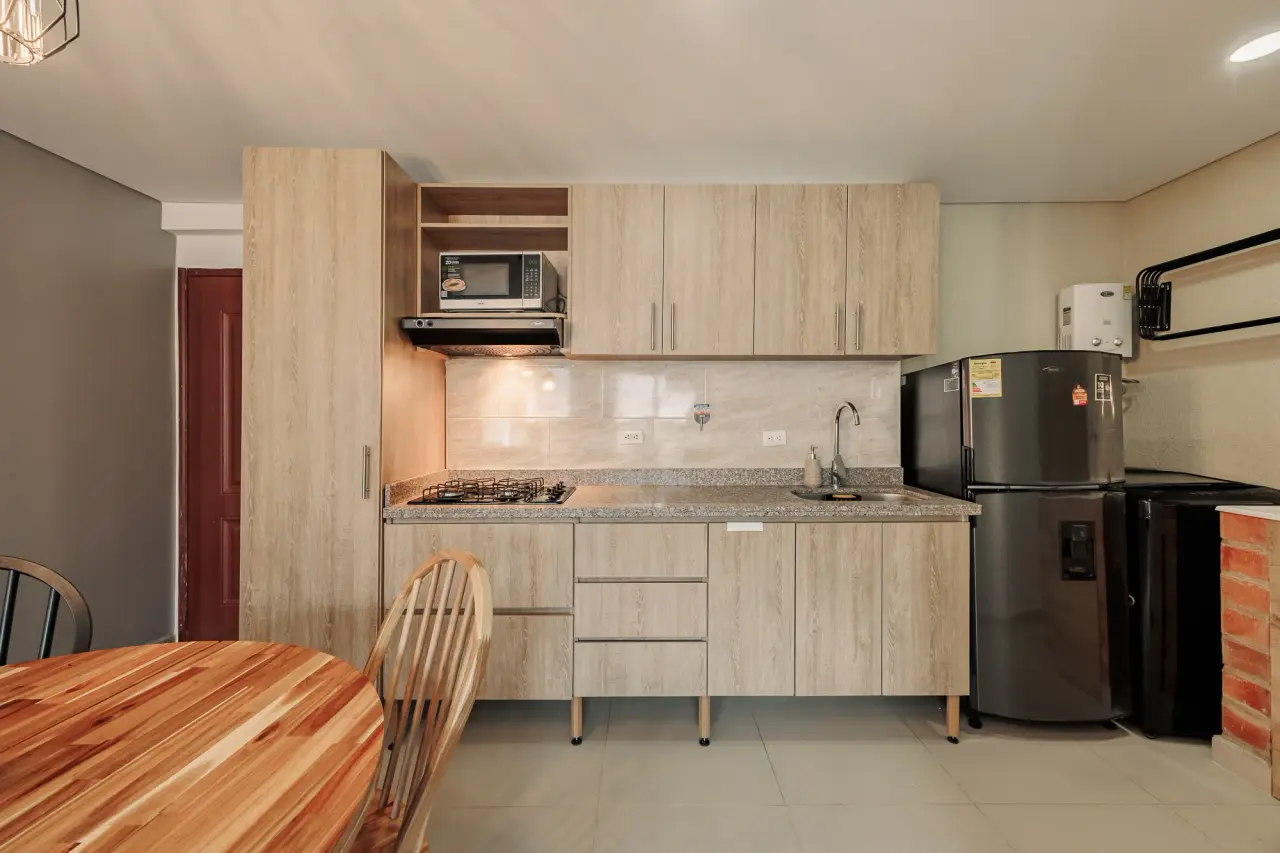 Fully equipped kitchen with oak cabinetry, granite counters and a full-size fridge at Casa Roble