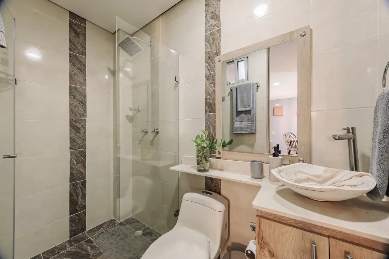 Bathroom with a walk-in shower and a stone vessel sink at Casa Roble