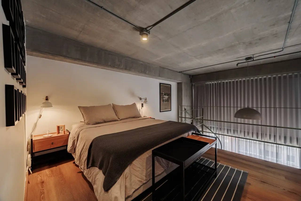 Mezzanine bedroom against the fluted wall, open to the living room below