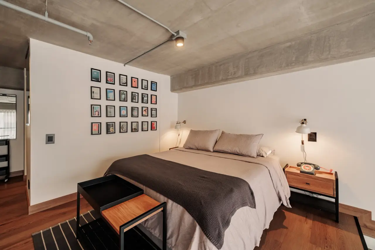 Queen bed on the mezzanine, with the gallery wall and reading lights