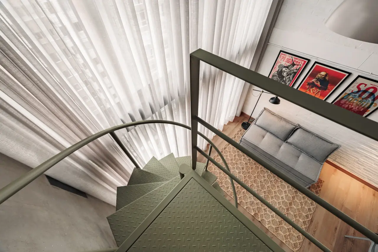 Looking down the spiral stair to the sofa and the rug below