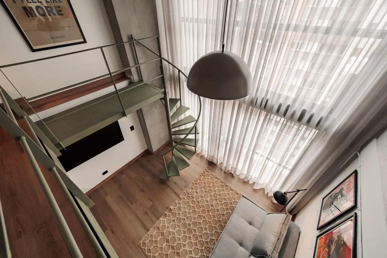 Looking down from the mezzanine into the living room and its pendant lamp