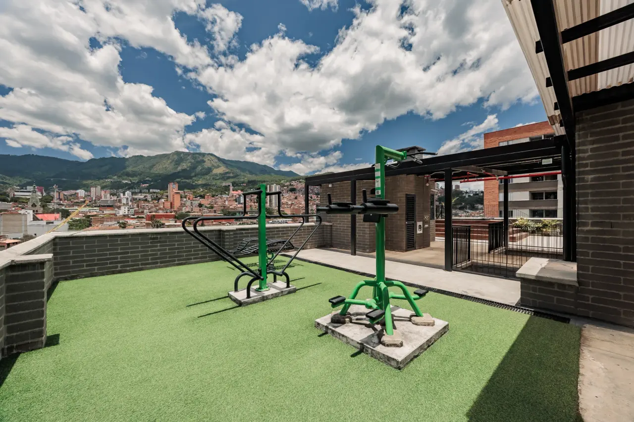 Rooftop terrace with a green deck and outdoor gym equipment